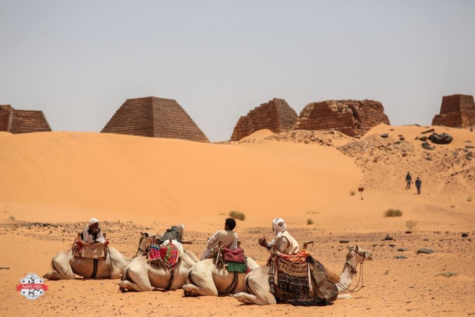 In this Thursday، April 16، 2015 photo، tour guides wait for tourists to offer them camel rides at the historic Meroe pyramids in al-Bagrawiya، 200 kilometers (125 miles) north of Khartoum، Sudan. The pyramids at Meroe are deserted despite being a UNESCO World Heritage site like those at Giza in Egypt. (AP Photo/Mosa'ab Elshamy)