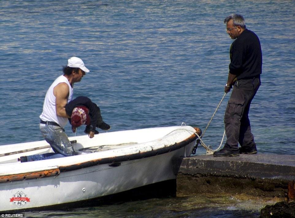 27C83F6400000578-3046653-Horrendous_sight_A_man_carries_the_body_of_a_dead_child_onto_the-m-15_1429540210794