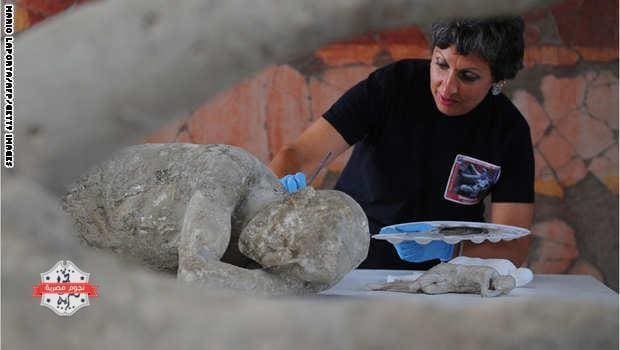 A restorer cleans and analyses a petrified victim of the eruption of Vesuvius volcano in 79 BC، as part of the restoration work and the study of 86 casts in the laboratory of Pompeii Archaeological Site، on May 20، 2015 in Pompeii. AFP PHOTO / MARIO LAPORTA (Photo credit should read MARIO LAPORTA/AFP/Getty Images)