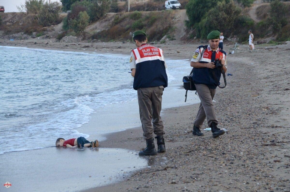 ATTENTION EDITORS - VISUAL COVERAGE OF SCENES OF DEATH OR INJURY A Turkish gendarmerie stands next to a young migrant، who drowned in a failed attempt to sail to the Greek island of Kos، as he lies on the shore in the coastal town of Bodrum، Turkey، September 2، 2015. At least 11 migrants believed to be Syrians drowned as two boats sank after leaving southwest Turkey for the Greek island of Kos، Turkey's Dogan news agency reported on Wednesday. It said a boat carrying 16 Syrian migrants had sunk after leaving the Akyarlar area of the Bodrum peninsula، and seven people had died. Four people were rescued and the coastguard was continuing its search for five people still missing. Separately، a boat carrying six Syrians sank after leaving Akyarlar on the same route. Three children and one woman drowned and two people survived after reaching the shore in life jackets. REUTERS/Nilufer Demir/DHA ATTENTION EDITORS - NO SALES. NO ARCHIVES. FOR EDITORIAL USE ONLY. NOT FOR SALE FOR MARKETING OR ADVERTISING CAMPAIGNS. TEMPLATE OUT. THIS IMAGE HAS BEEN SUPPLIED BY A THIRD PARTY. IT IS DISTRIBUTED، EXACTLY AS RECEIVED BY REUTERS، AS A SERVICE TO CLIENTS. TURKEY OUT. NO COMMERCIAL OR EDITORIAL SALES IN TURKEY.