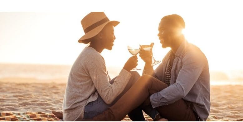البرود العاطفي للزوج.. كيف تتعاملين معه؟.. يبدو في الصورة رجل وامرأة وغروب الشمس من خلفهم