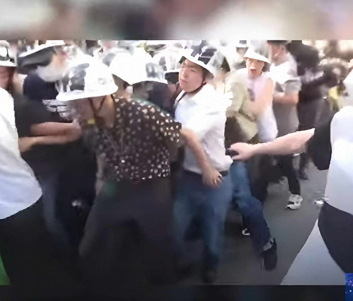 طلاب جامعيون باليابان يتشبثون بأيدي بعضهم البعض ويرتدون الخوذات